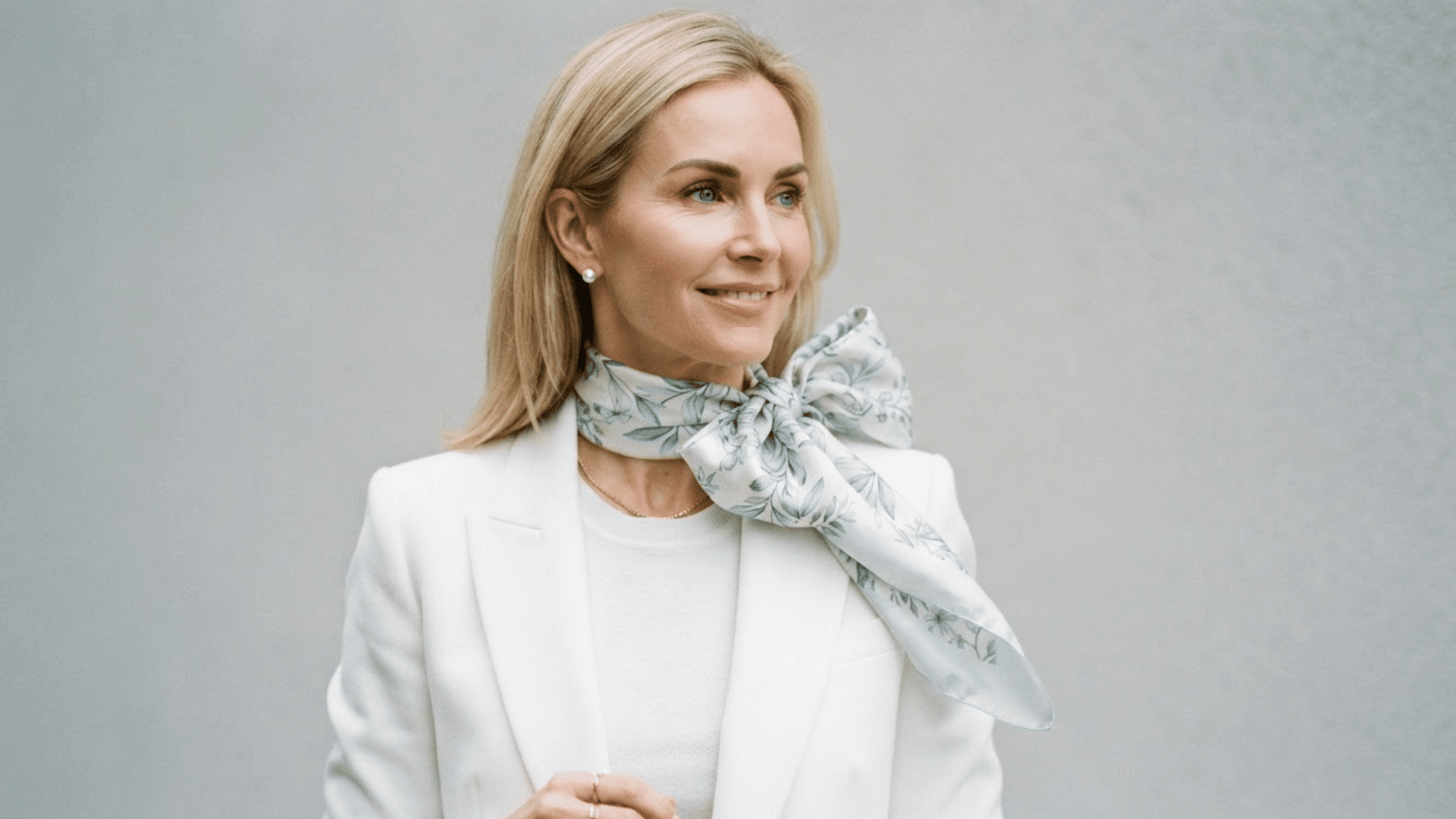 scarf styled into a statement bow adding a feminine and eye catching touch to an outfit