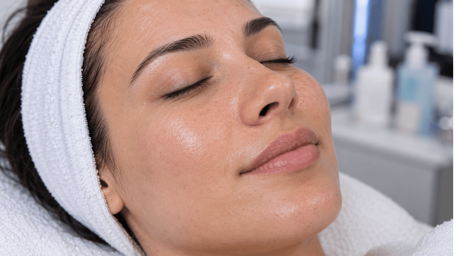 woman resting with eyes closed and a white headband during a hydrafcial skincare treatment