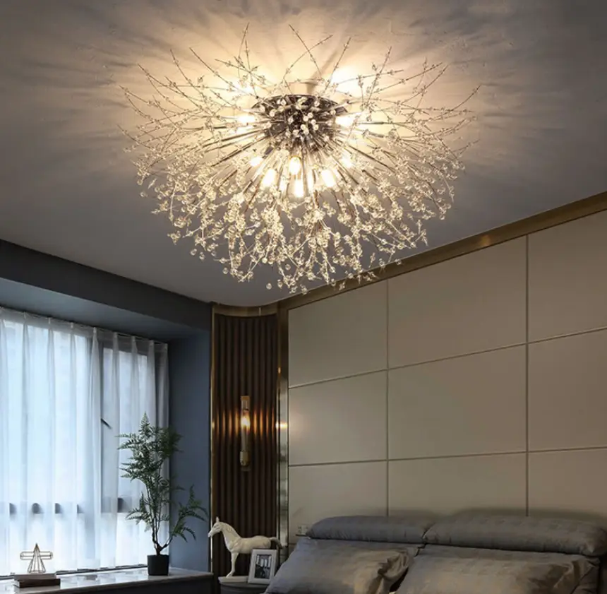 Shimmering chandelier with crystal branches illuminating a modern bedroom with gray accents